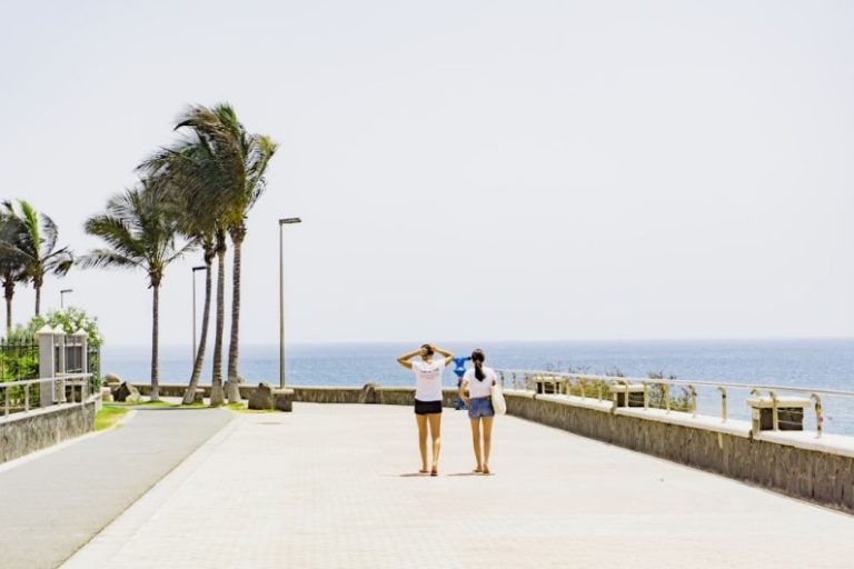 Island Resorts - two women walking beside body of water