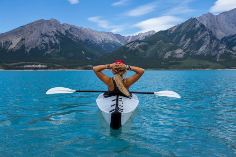 Adventure Sports - woman riding kayak at the middle of the sea