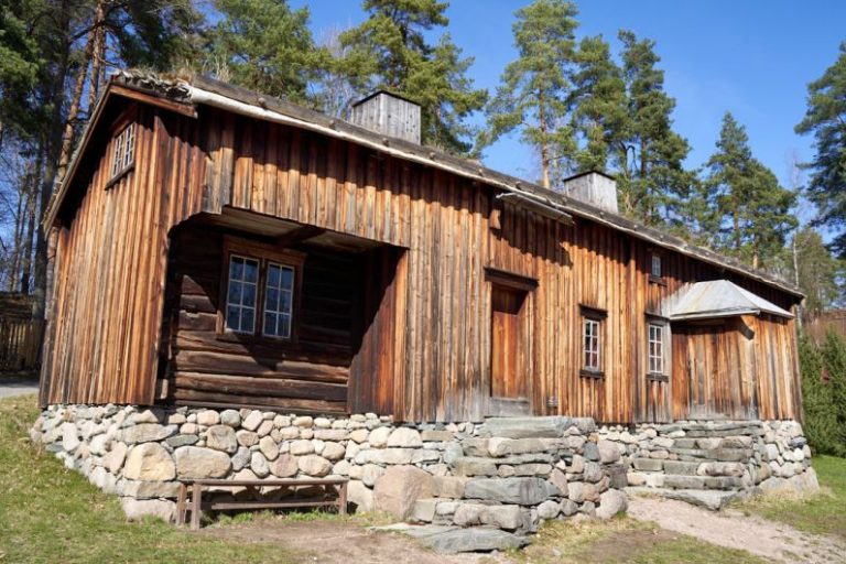 Mountain Lodges - a wooden building with a stone wall and a bench in front of it